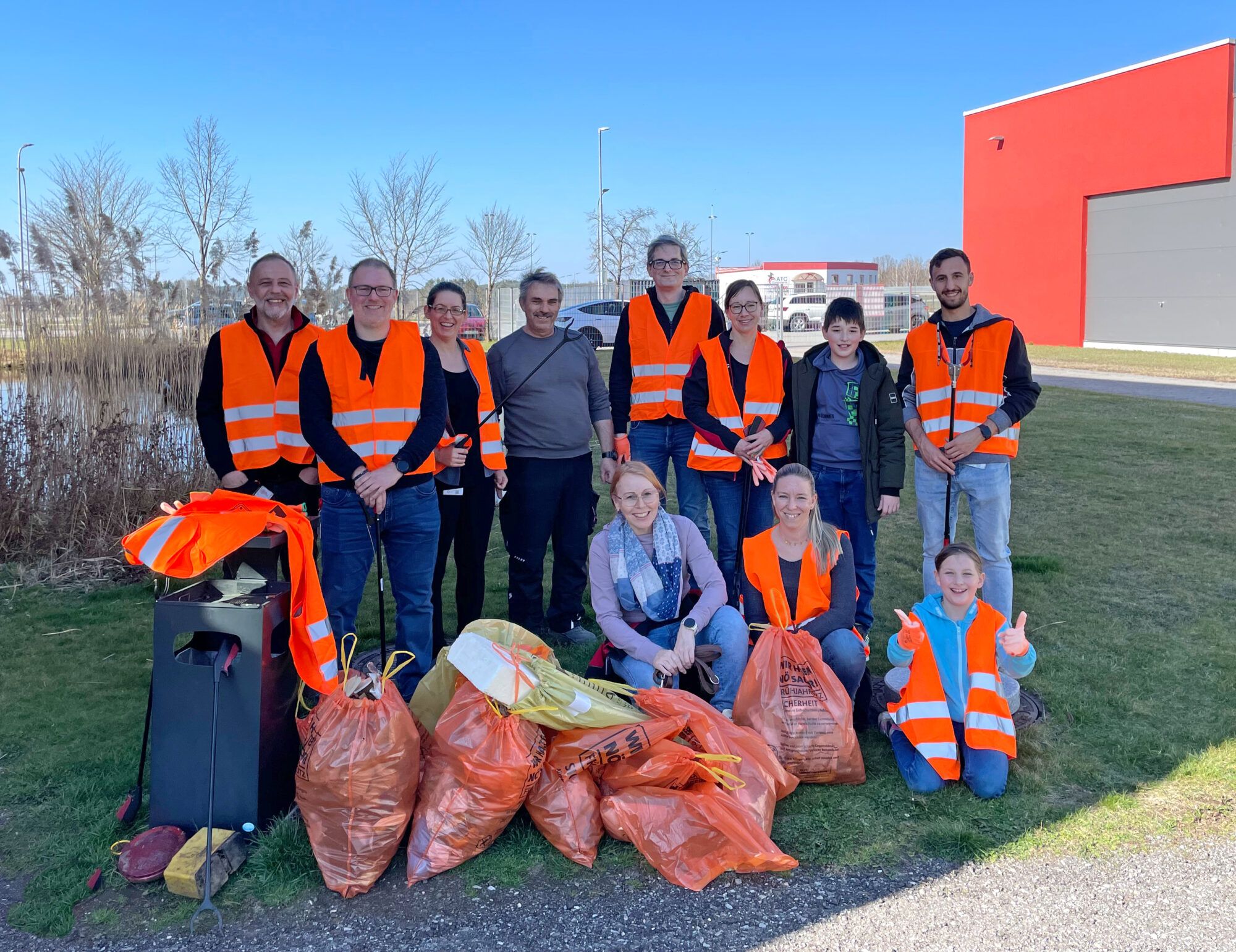 Gruppenbild der HelferInnen und Helfer der Frühjahrsputzaktion der Firma NBG Gmünd mit dem in der Natur gesammelten Abfall