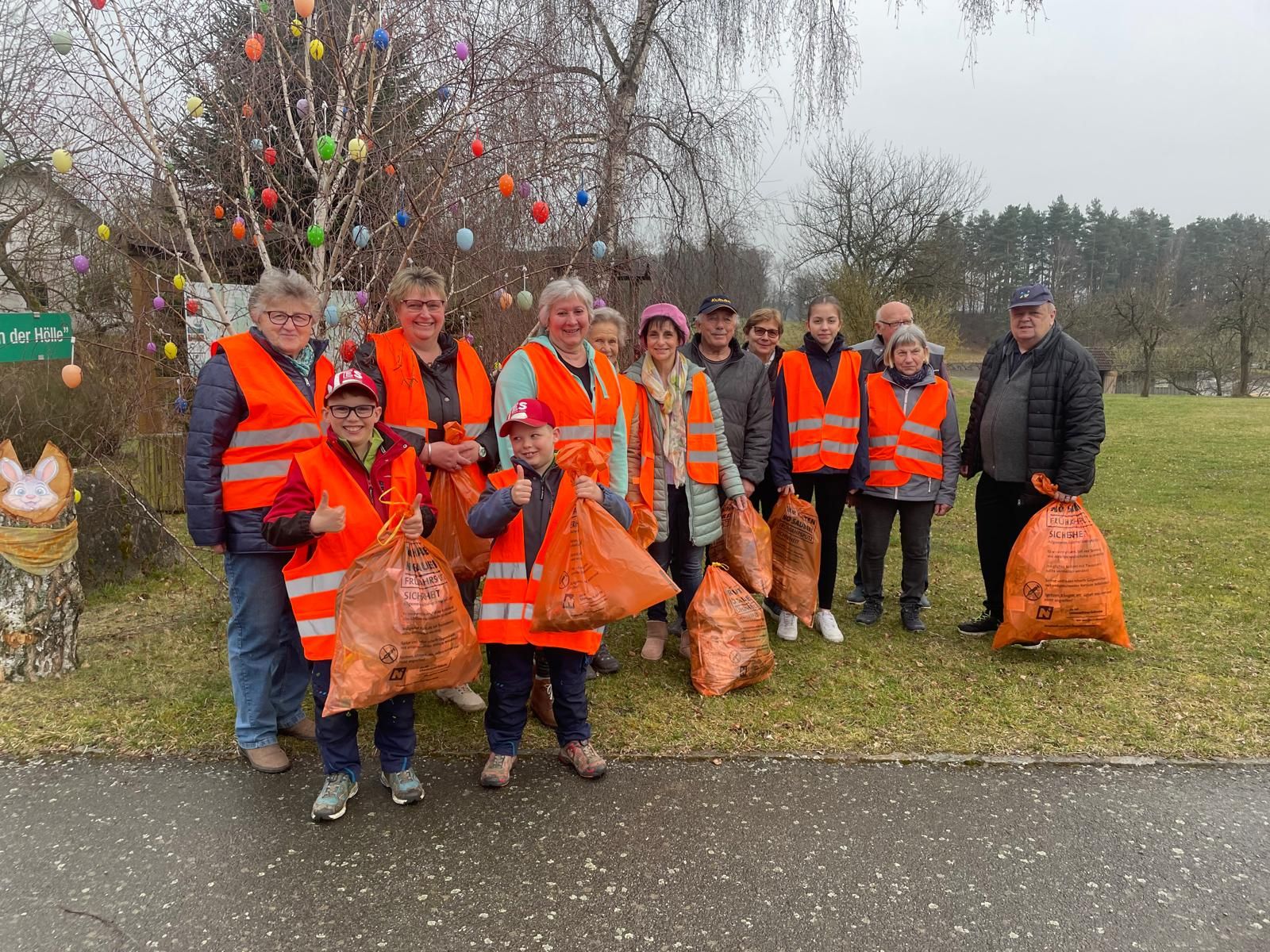 Gruppenbild der HelferInnen und Helfer der Frühjahrsputzaktion Illmanns mit dem in der Natur gesammelten Abfall