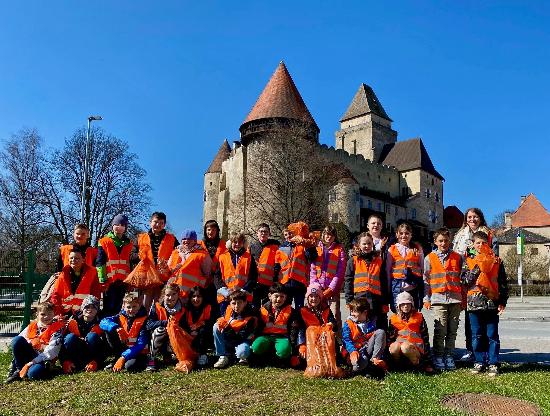 Gruppenbild der HelferInnen und Helfer der Frühjahrsputzaktion NMS Heidenreichstein Klasse 4 a und b mit dem in der Natur gesammelten Abfall