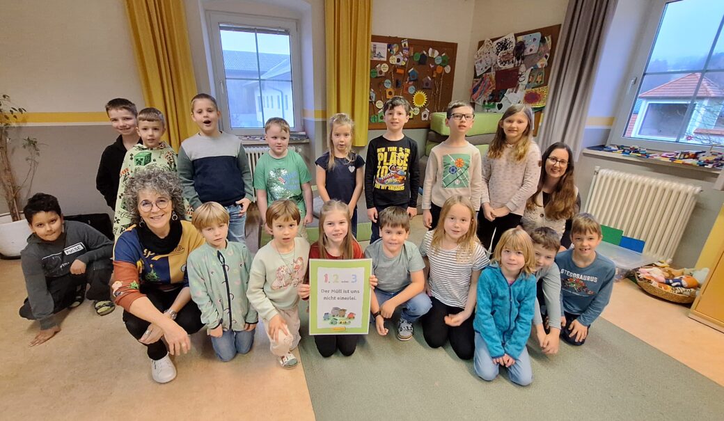 Auf diesem Foto sieht man zwei erwachsene Personen und Kinder einer Schulklasse